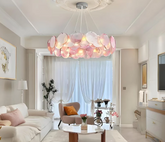 Pink Murano glass discs arranged in a circular chandelier, suspended from a white ceiling with ornate molding.