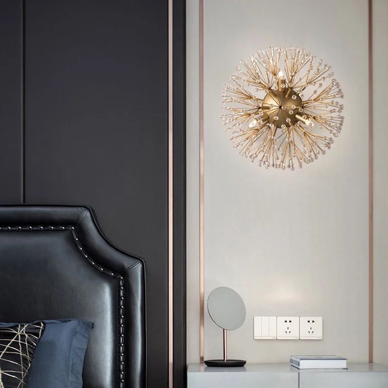 A bedroom setting with a gold sputnik-style crystal wall sconce mounted on a white wall next to a black leather headboard.