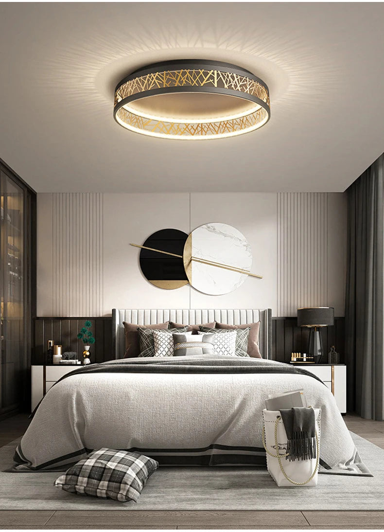 Modern bedroom with a ceiling light fixture, bed, and decorative pillows.