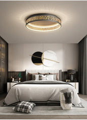 Modern bedroom with a ceiling light fixture, bed, and decorative pillows.