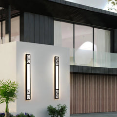 Two black geometric LED wall sconces mounted on a modern building facade, flanking the entrance.