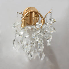 Gold wall sconce with crystal accents on a gray background