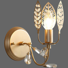 Decorative wall sconce with gold finish and crystal accents on a white background