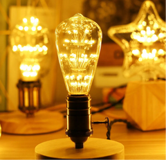 Vintage-style light bulb on a wooden base with warm glow