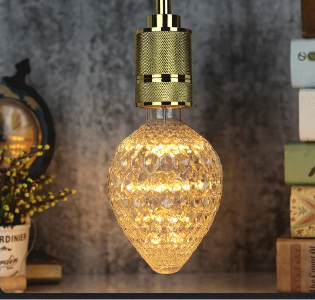 Decorative light bulb with gold fixture on a blurred background