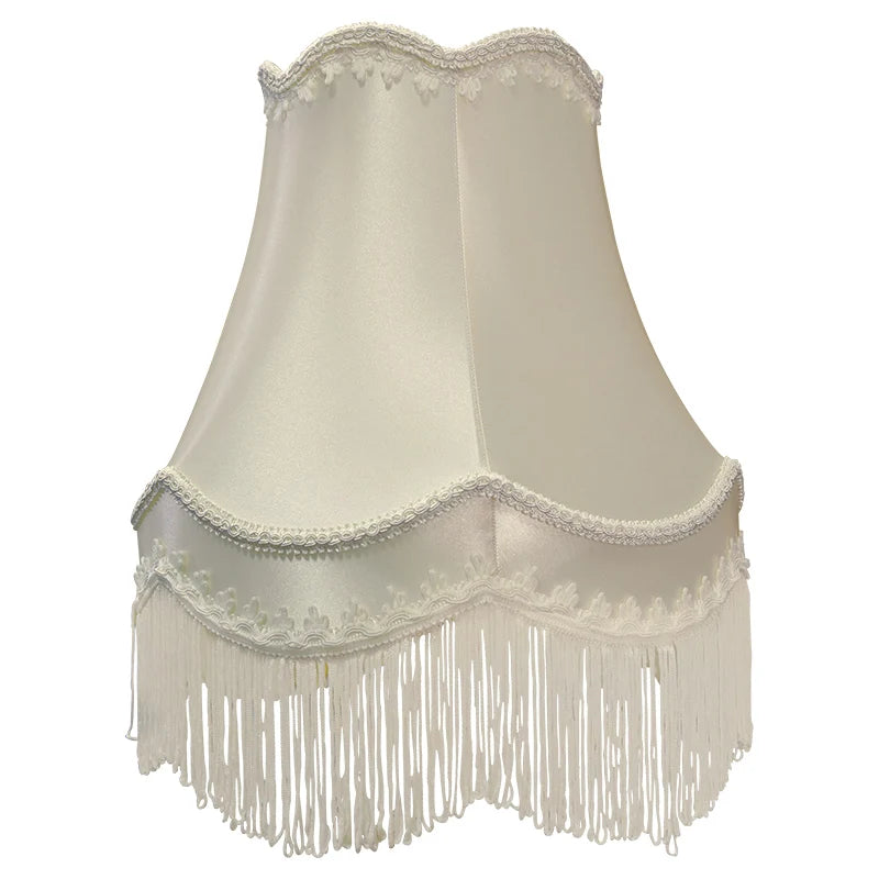 Cream fabric bell lampshade with decorative white fringe and scalloped trim