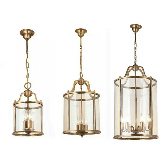 Three brass cylinder glass chain pendant lights of varying sizes arranged side-by-side