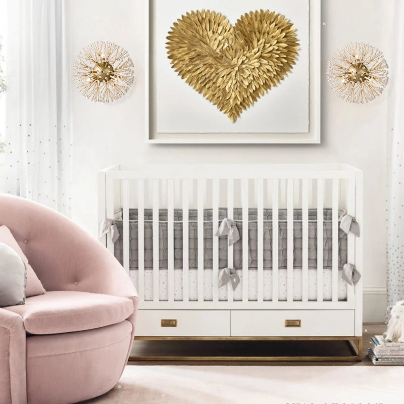 A nursery room featuring two gold sputnik-style crystal wall sconces mounted on the wall above a crib and a pink chair.