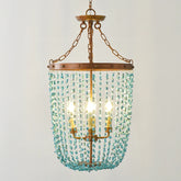 Turquoise stone beads cascading from a distressed gold frame on a multi-light chandelier, front view.