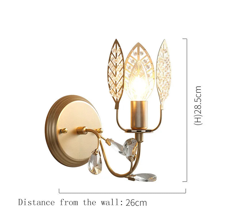 Decorative wall lamp with leaf and crystal design on a white background