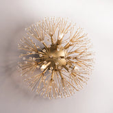 Close-up of a gold sputnik-style wall sconce with radiating arms covered in clear crystals against a white background.