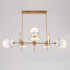 Modern chandelier with gold frame and marble-like finishes on a light gray background