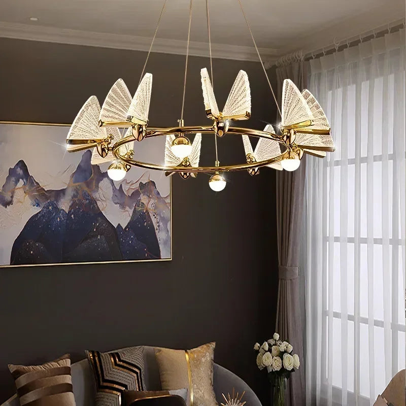 Gold ring chandelier with clear, translucent butterfly-shaped shades and globe lights, in a room setting.
