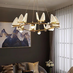 Gold ring chandelier with clear, translucent butterfly-shaped shades and globe lights, in a room setting.