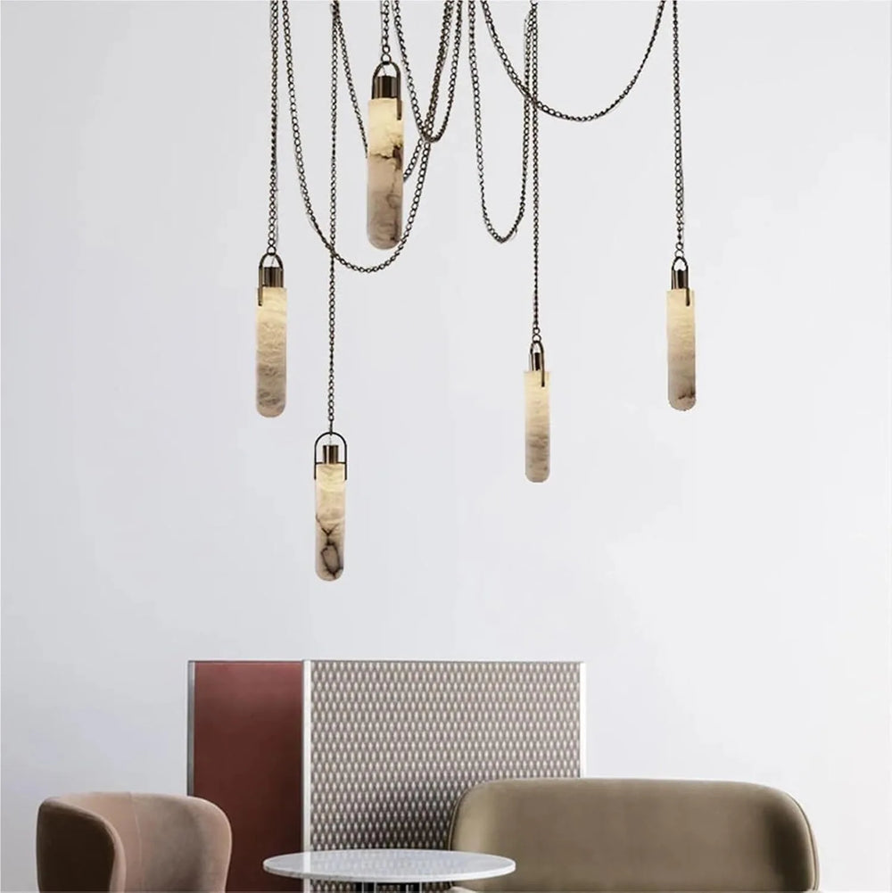 Modern pendant lights hanging above a table and chairs with a neutral background