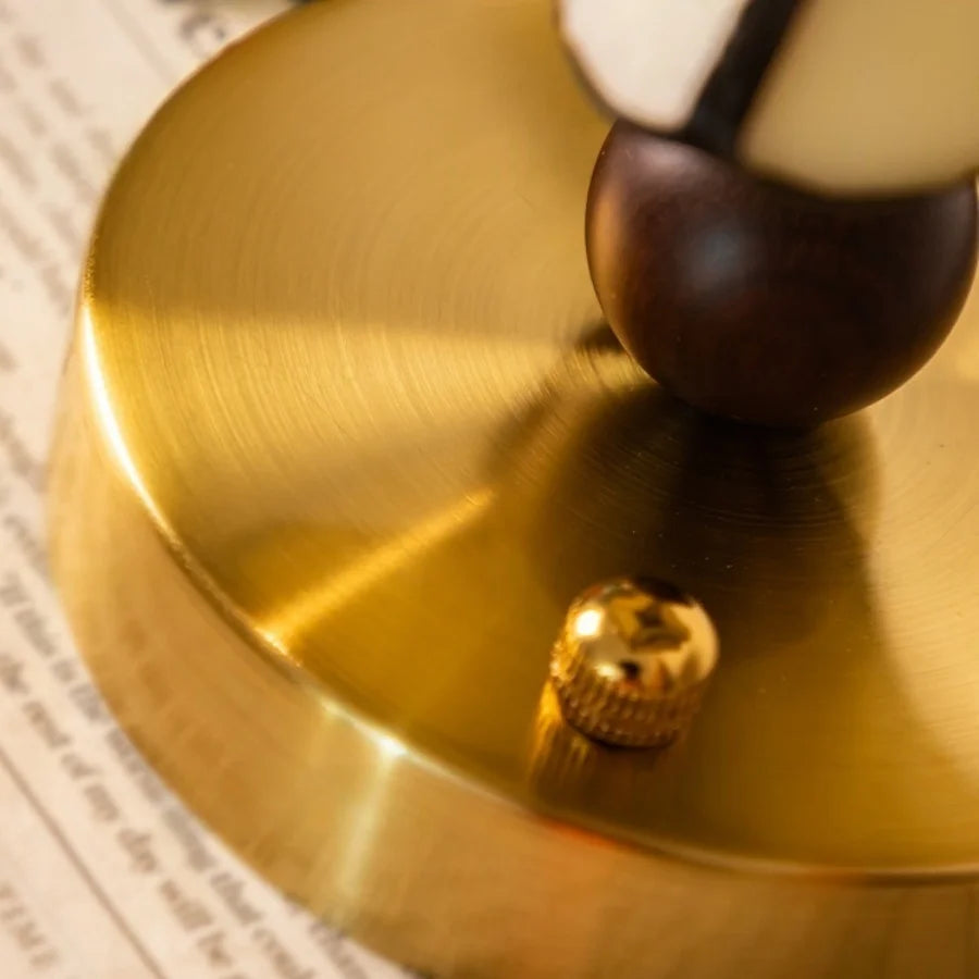 Close-up of a gold bell with a wooden handle on a newspaper background