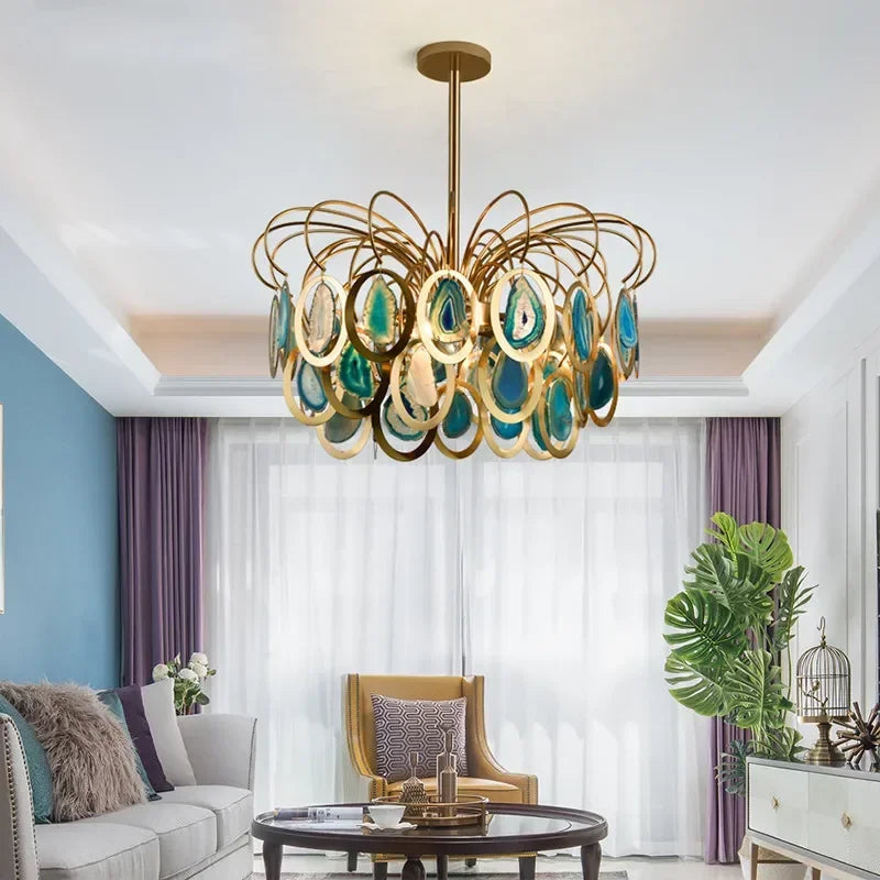 A gold chandelier with agate slices hangs in a brightly lit living room with purple curtains.