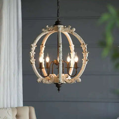 Close-up of a distressed white carved wood globe chandelier with ornate detailing and four visible E14 bulbs.