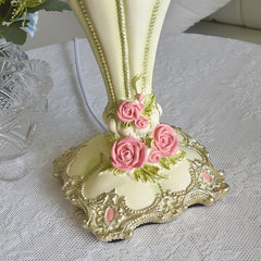 Decorative vase with pink roses on a textured surface