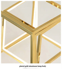 Gold metal lamp body with geometric design on a white background