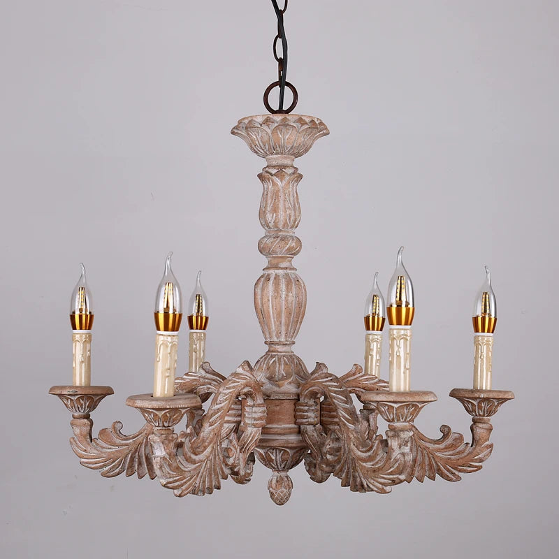 A distressed wood candelabra chandelier with multiple arms and candle-shaped lights, showcasing its ornate carvings and rustic finish.