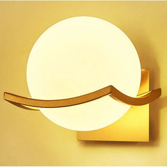 Modern wall lamp with a gold frame and white round shade on a yellow background