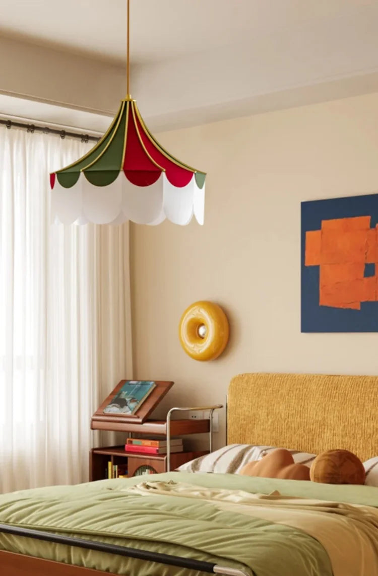 Bedroom with colorful pendant light, wall art, and a bed with green bedding.