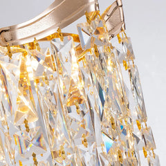Close-up of a gold and crystal chandelier against a light gray background