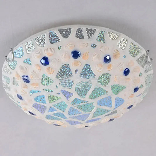 Close-up of a mosaic glass seashell flush mount ceiling light with blue gem accents and iridescent tiles