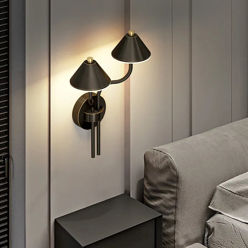Pair of brass modern mushroom wall sconces flanking a doorway.