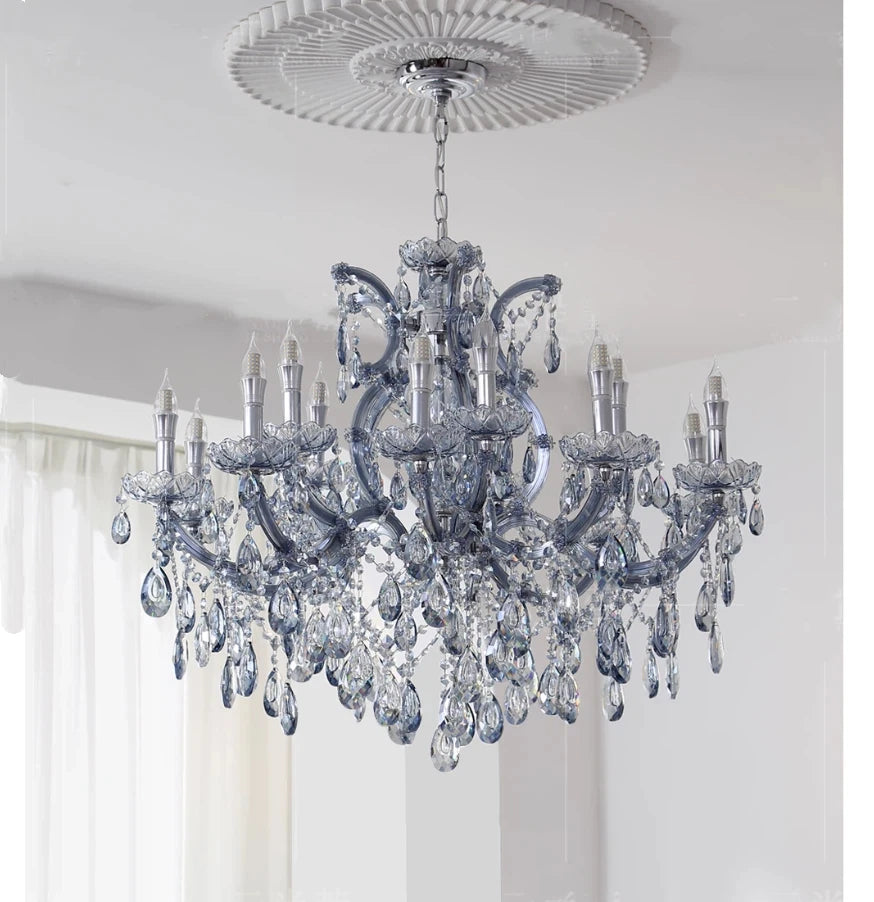 A crystal chandelier with a grey metal frame, showcasing its cascading crystal design and candle-style bulbs.
