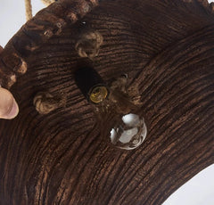 Close-up of a wooden lamp with a clear glass shade and visible wiring.