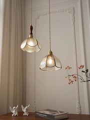 Two hanging pendant lights with floral glass shades in a room setting.