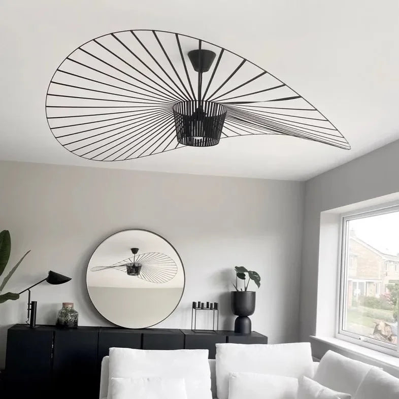 Modern living room with black ceiling light fixture and round mirror.
