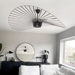 Modern living room with black ceiling light fixture and round mirror.