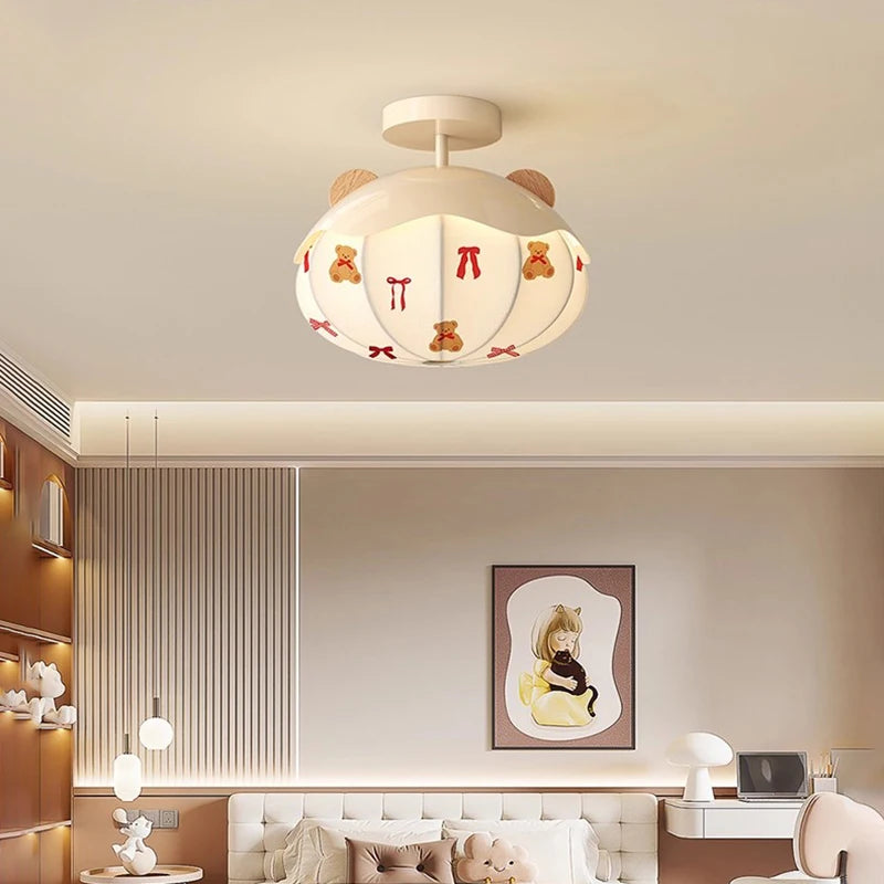 White ceiling light with a hot air balloon motif and teddy bear and ribbon decals, installed in a child's bedroom setting.