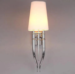 Wall-mounted lamp with a white shade and chrome base on a gray background