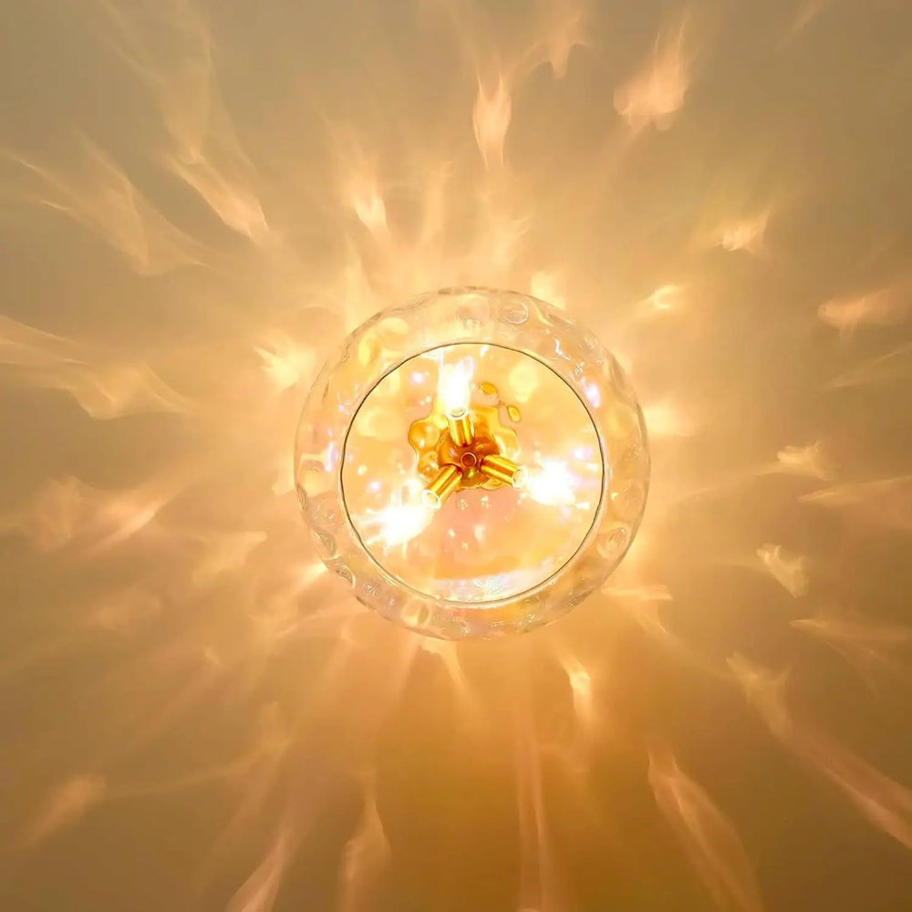 Top-down view of a gold water ripple glass pendant light, illuminating a ceiling with a textured, wavy light pattern.