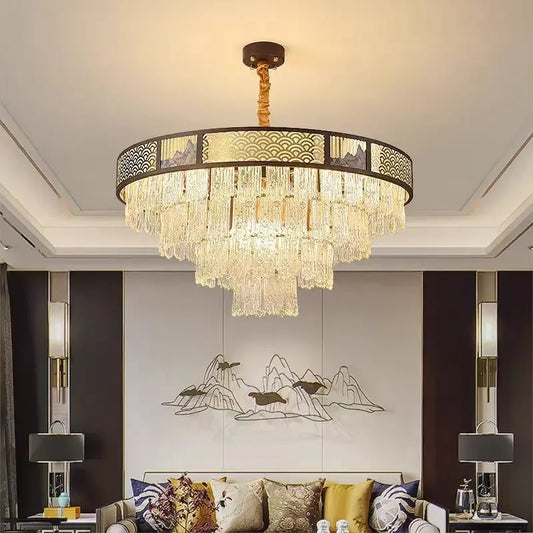 Tiered crystal chandelier with a dark frame and clear crystal droplets, installed in a living room setting.