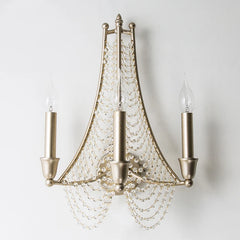 Close-up of the central mounting point of a silver metal wall sconce with crystal bead strands.