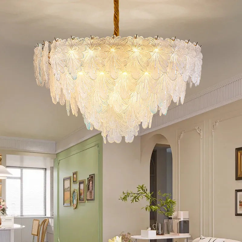 A close-up view of a multi-layered crystal leaf chandelier with a gold finish, showing intricate details.