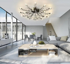 Modern living room with a chandelier, coffee table, and staircase.