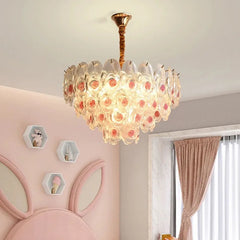Brushed gold floral chandelier with pink rose accents, installed in a child's bedroom.