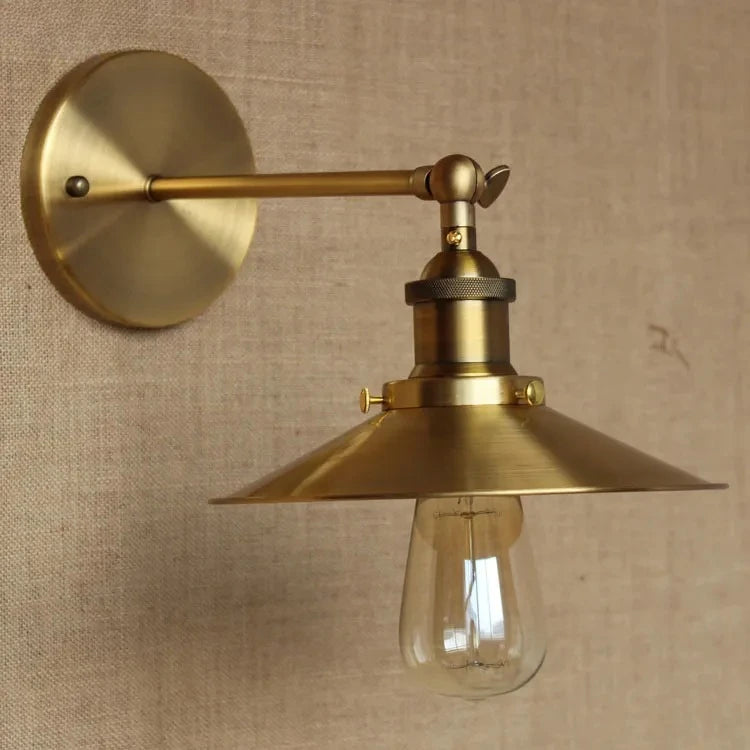 Side view of a gold cone shade wall sconce with an exposed Edison bulb.