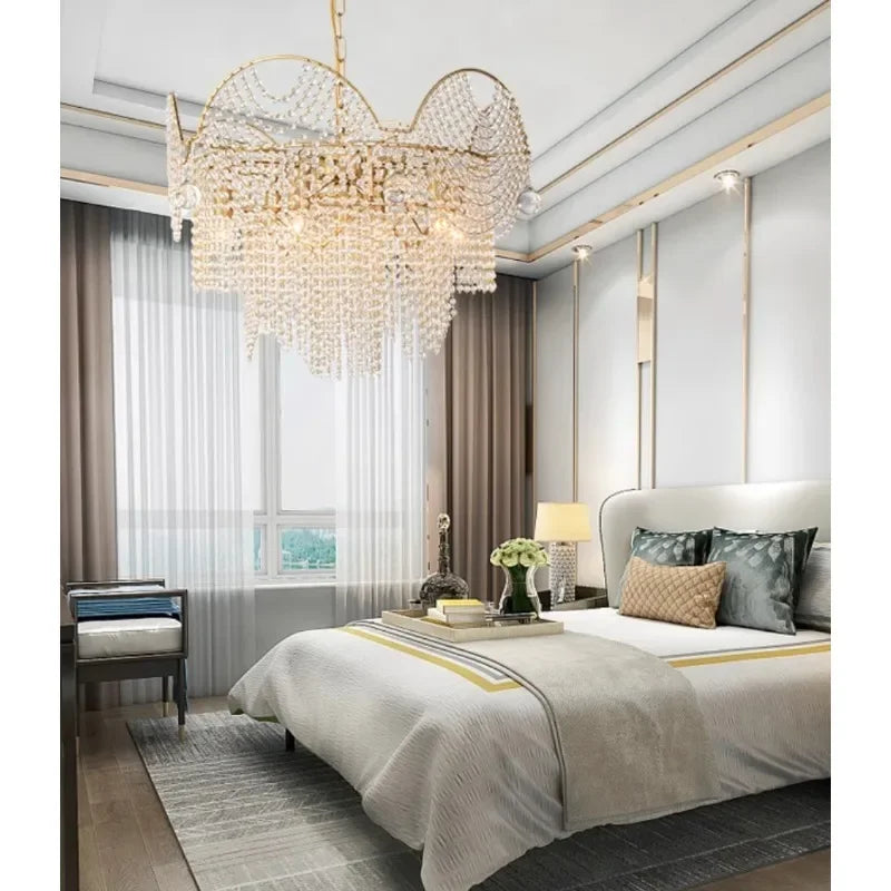 A luxurious bedroom with a large bed, dressed in white linens, and a gold cascading crystal chandelier suspended from the ceiling.