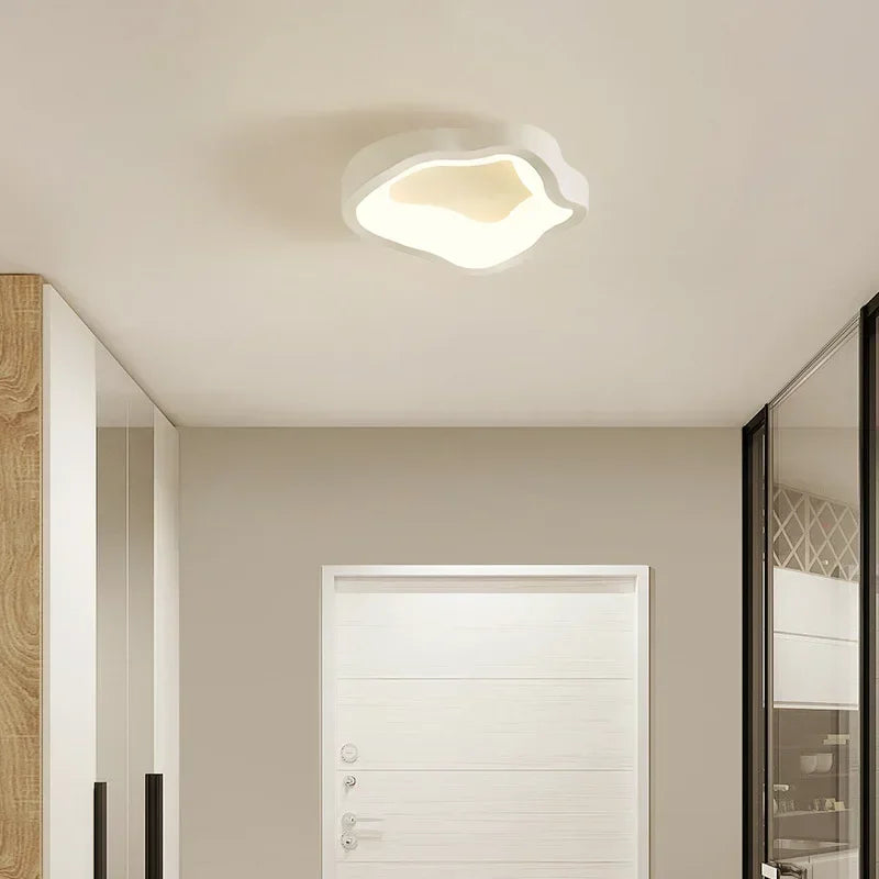 White wavy-shaped ceiling light mounted on a neutral ceiling with a white door in the background