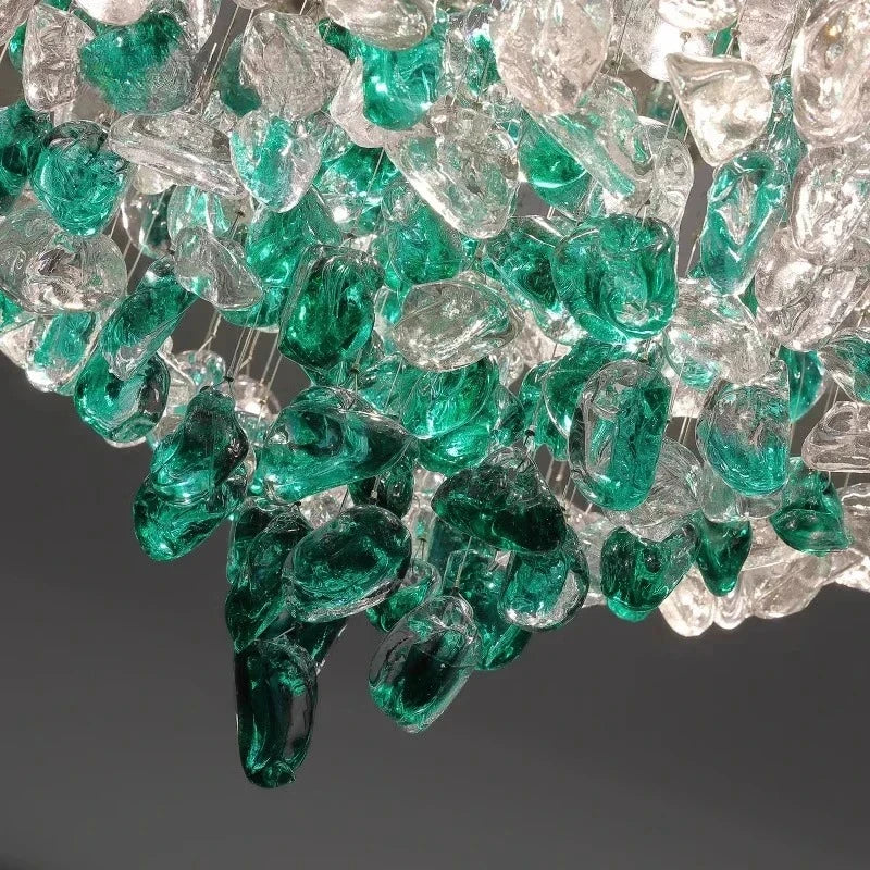 Detail shot of the clear and green glass-like crystals suspended from a circular chrome fixture.