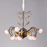 Brushed gold chandelier with pink stained glass flowers and multiple curved arms, suspended against a plain background.