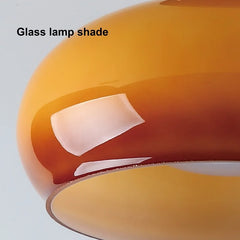 Close-up of a glass lamp shade with a white label on a light gray background