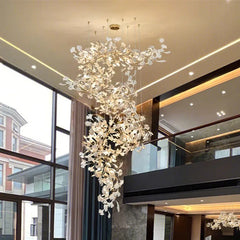Luxurious interior with a gold ginkgo leaf chandelier suspended from a high ceiling.